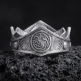 Load image into Gallery viewer, Oxidized Targaryen dragon ring on textured volcanic rock, close-up studio shot highlighting the three-headed dragon emblem, shield-like face, engraved band details, and antique silver contrast.