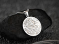 Load image into Gallery viewer, Close-up of round silver dragon necklace, mythical beast motif.
