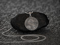 Load image into Gallery viewer, Hand holding silver dragon medallion, symbol of strength and luck.