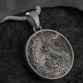 Load image into Gallery viewer, Close-up of round gold dragon medallion necklace with embossed fantasy motif,