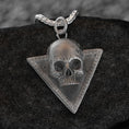 Load image into Gallery viewer, May include: A silver skull pendant with a detailed design. The skull is set in a triangular frame with a textured border. The pendant is on a silver chain.