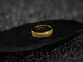 Load image into Gallery viewer, Yellow gold floral star wedding ring on dark stone background