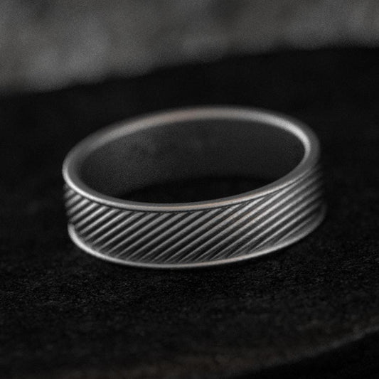 Front view of diagonal groove wedding band on stone background