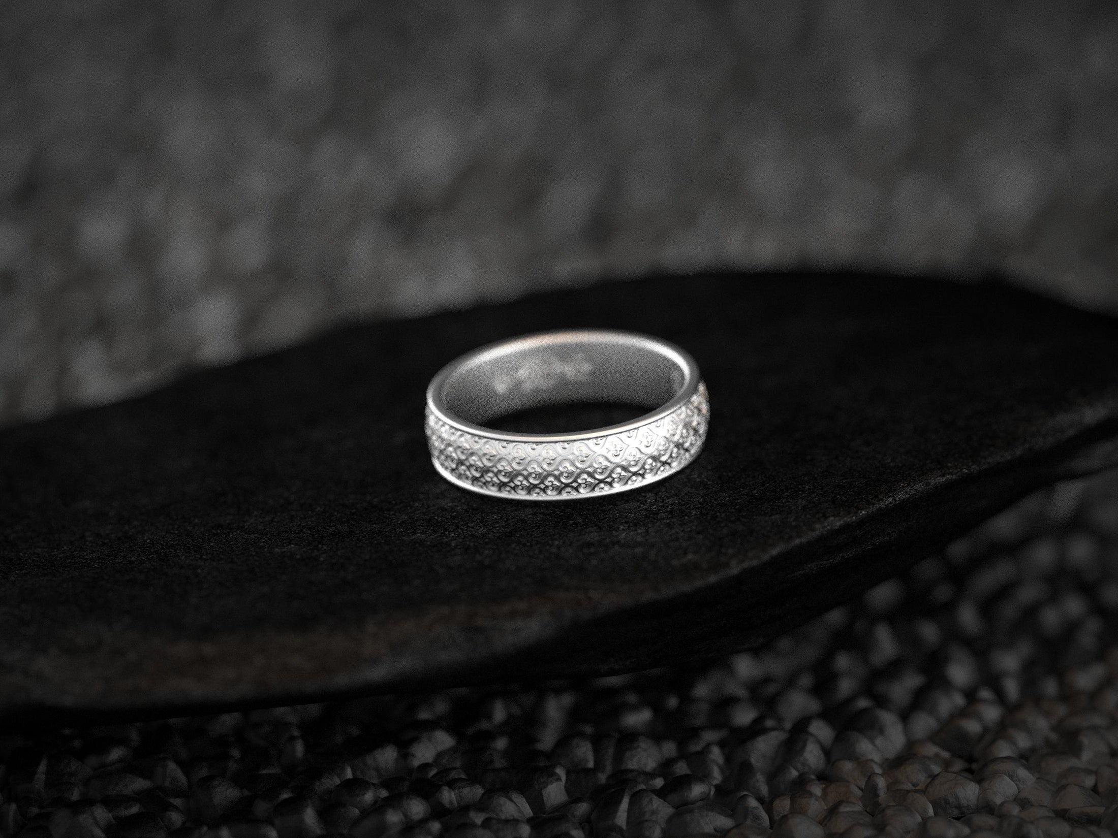 Polished silver braided floral ring with soft light reflections