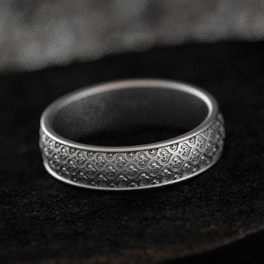 Oxidized silver wedding band with braided floral motif on black stone