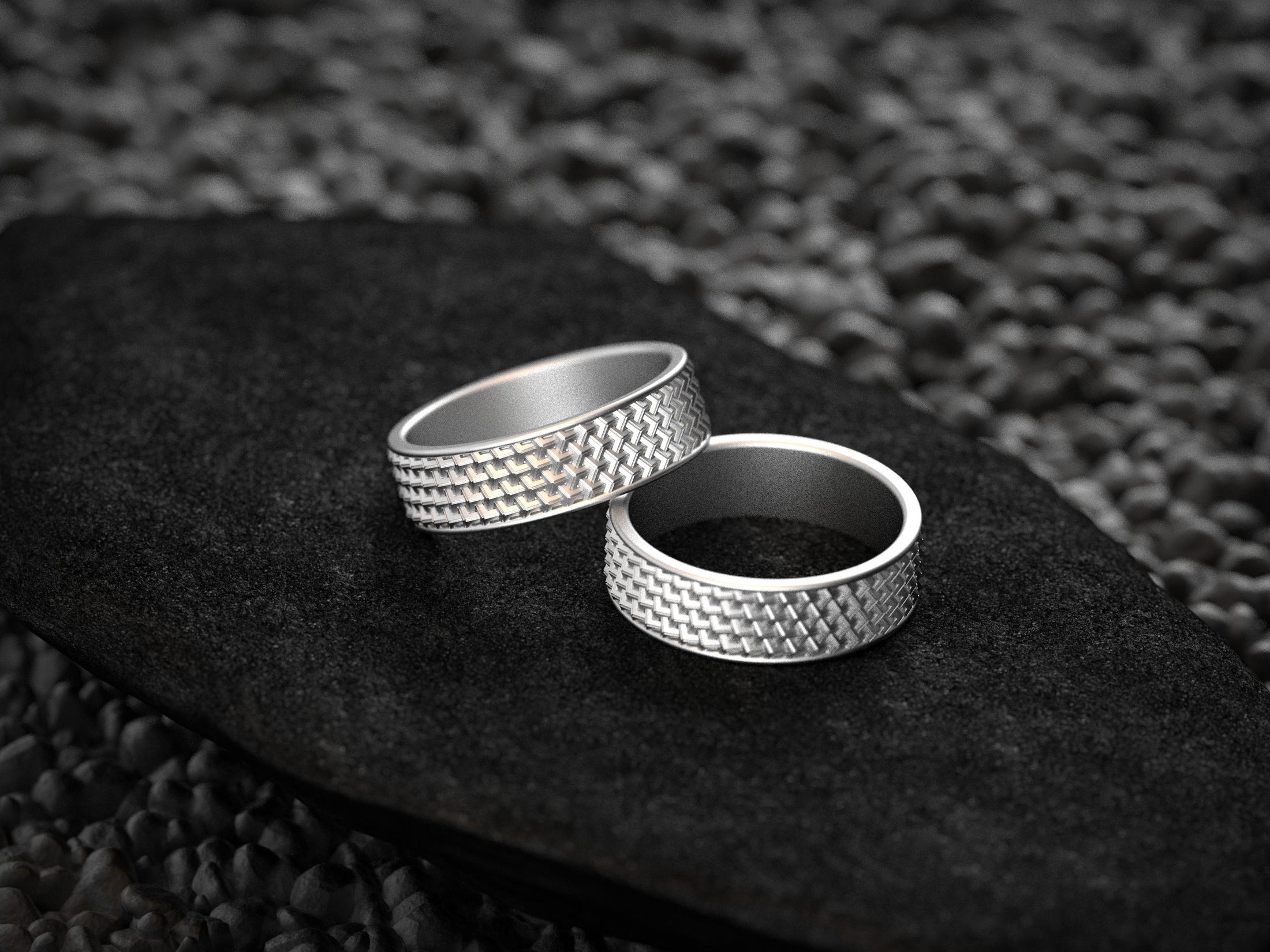 Two bright silver rings with structured grid design for couples