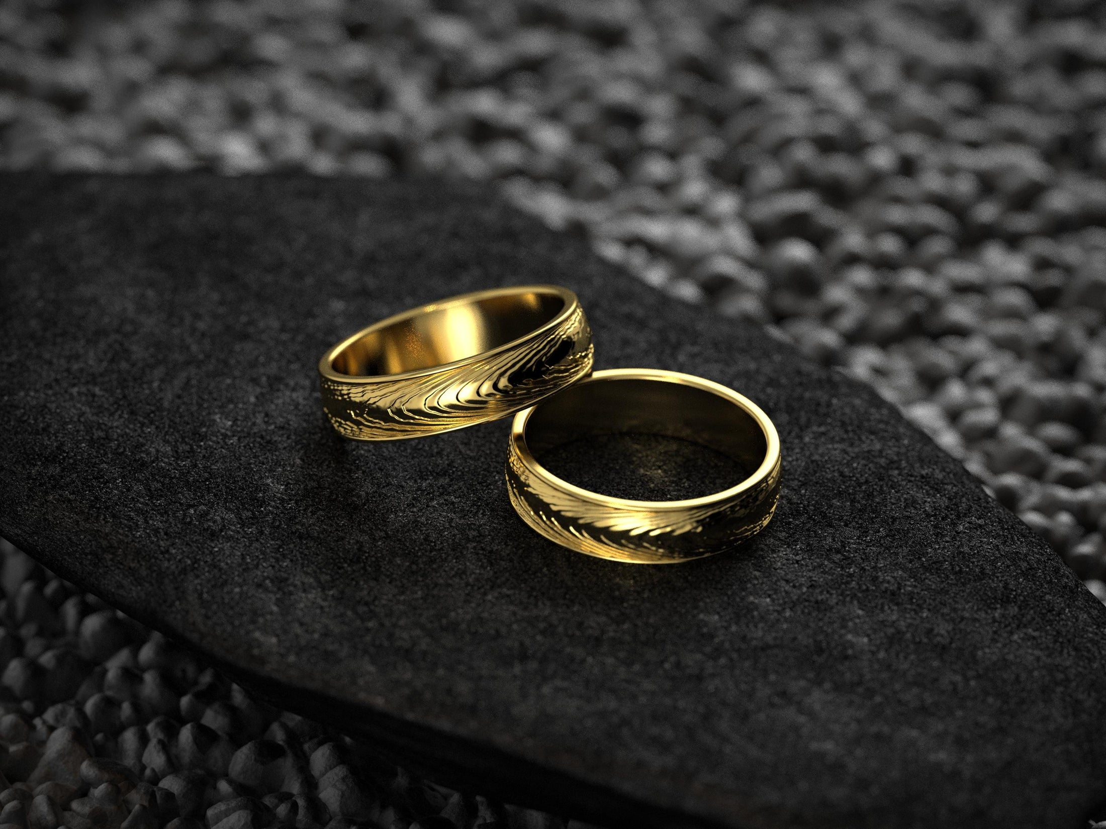 Pair of gold-plated rings showcasing grainy feather pattern