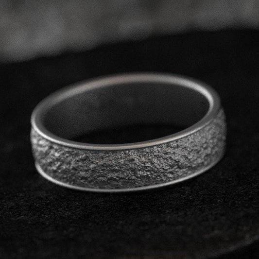 Rustic bark texture ring on dark stone background