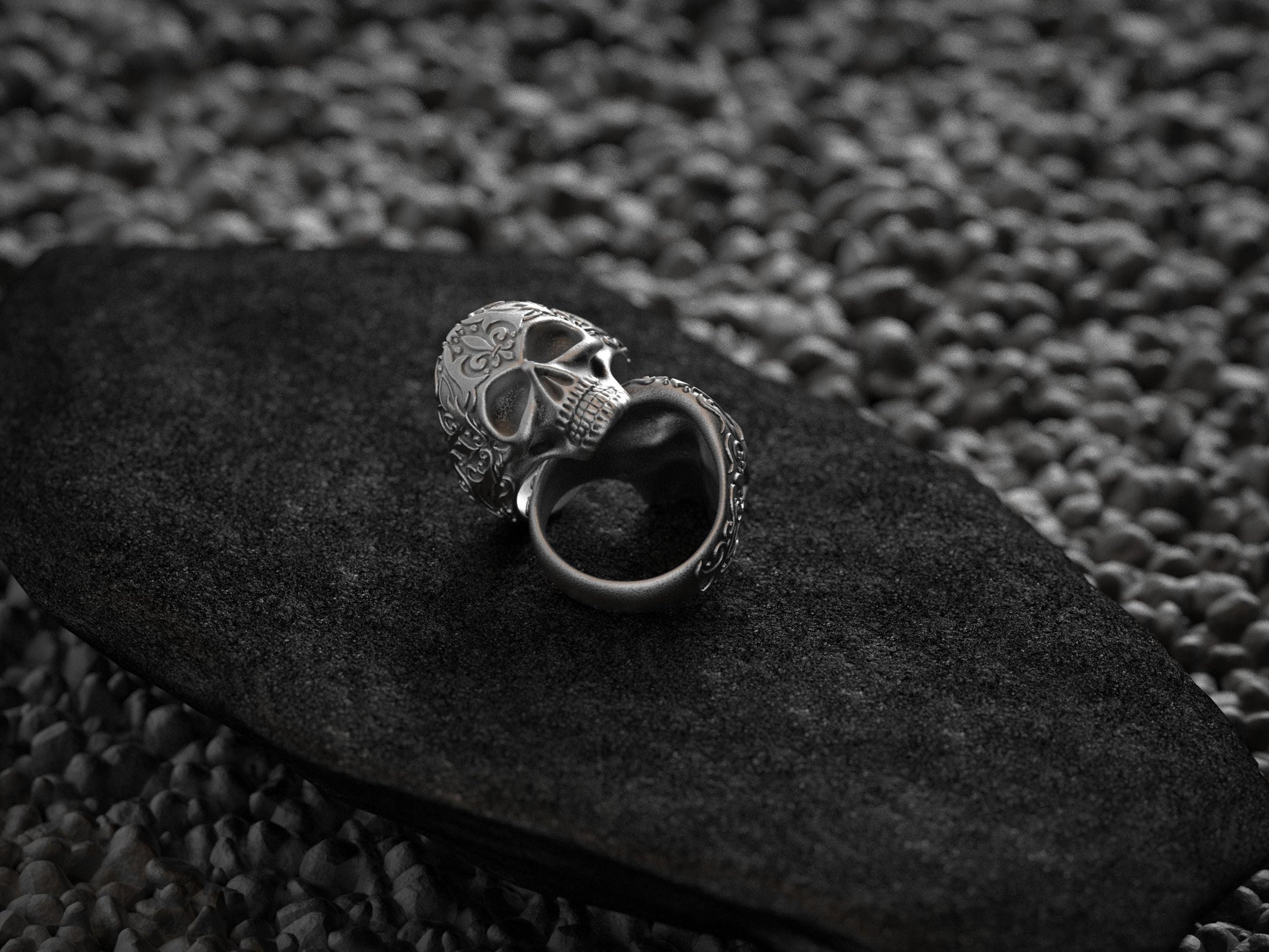 Side profile view of silver skull ring showcasing filigree ornament.