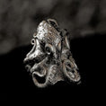 Load image into Gallery viewer, Close-up of sterling silver octopus signet ring on black stone.