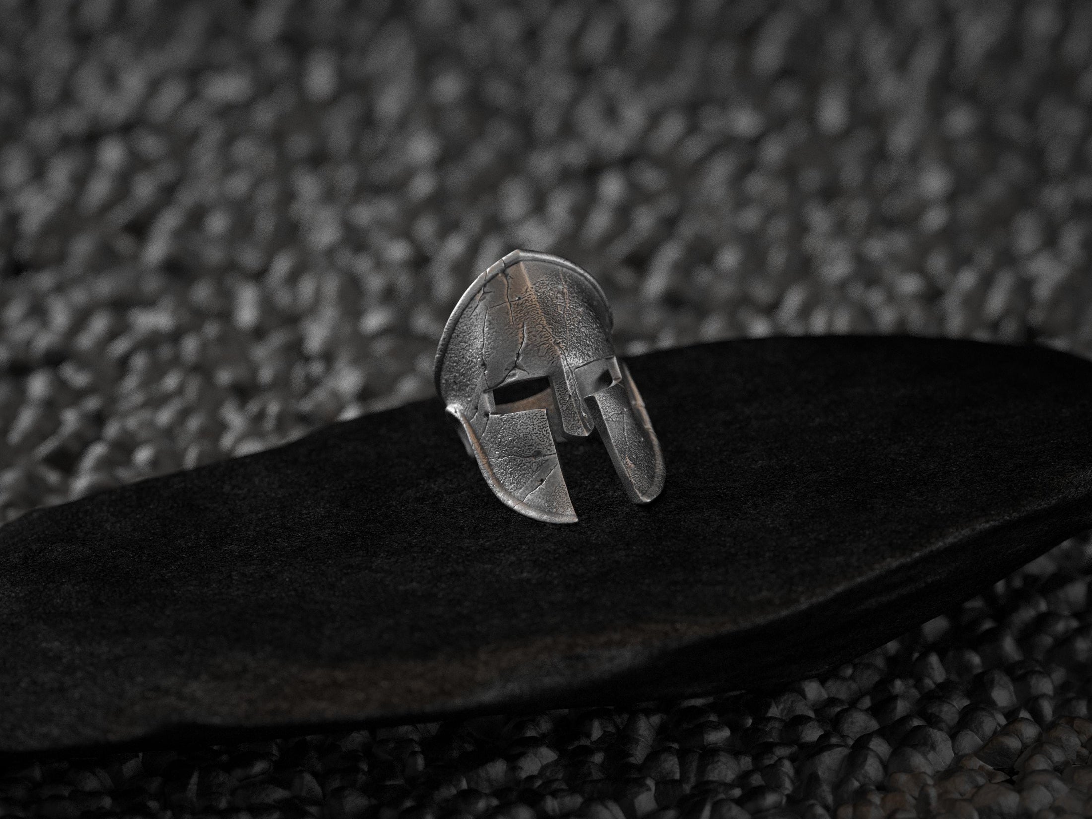 Three-quarter angle of the silver ring highlighting the depth of the helmet’s eye-slits and curved crest.