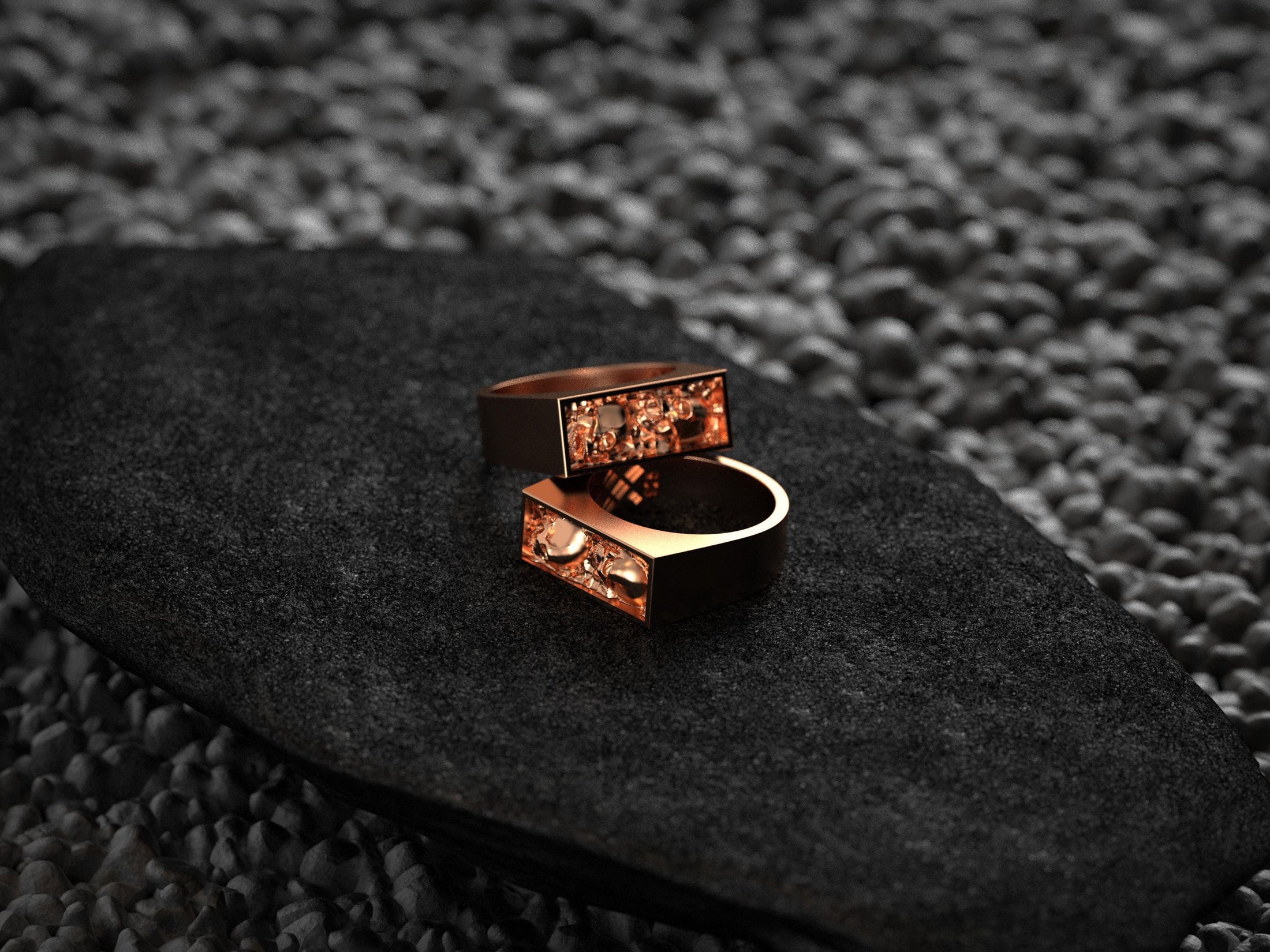 Angled shot of the rose-gold plated ring, accentuating the twin skull carvings and thin bezel border.