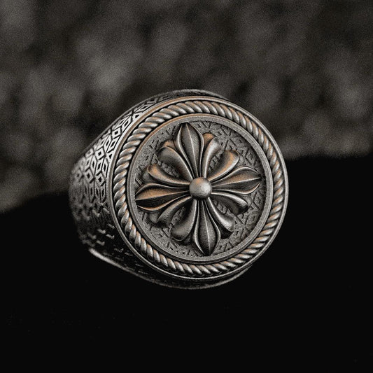 Sterling silver signet ring with fleur-de-lis shield on dark stone,