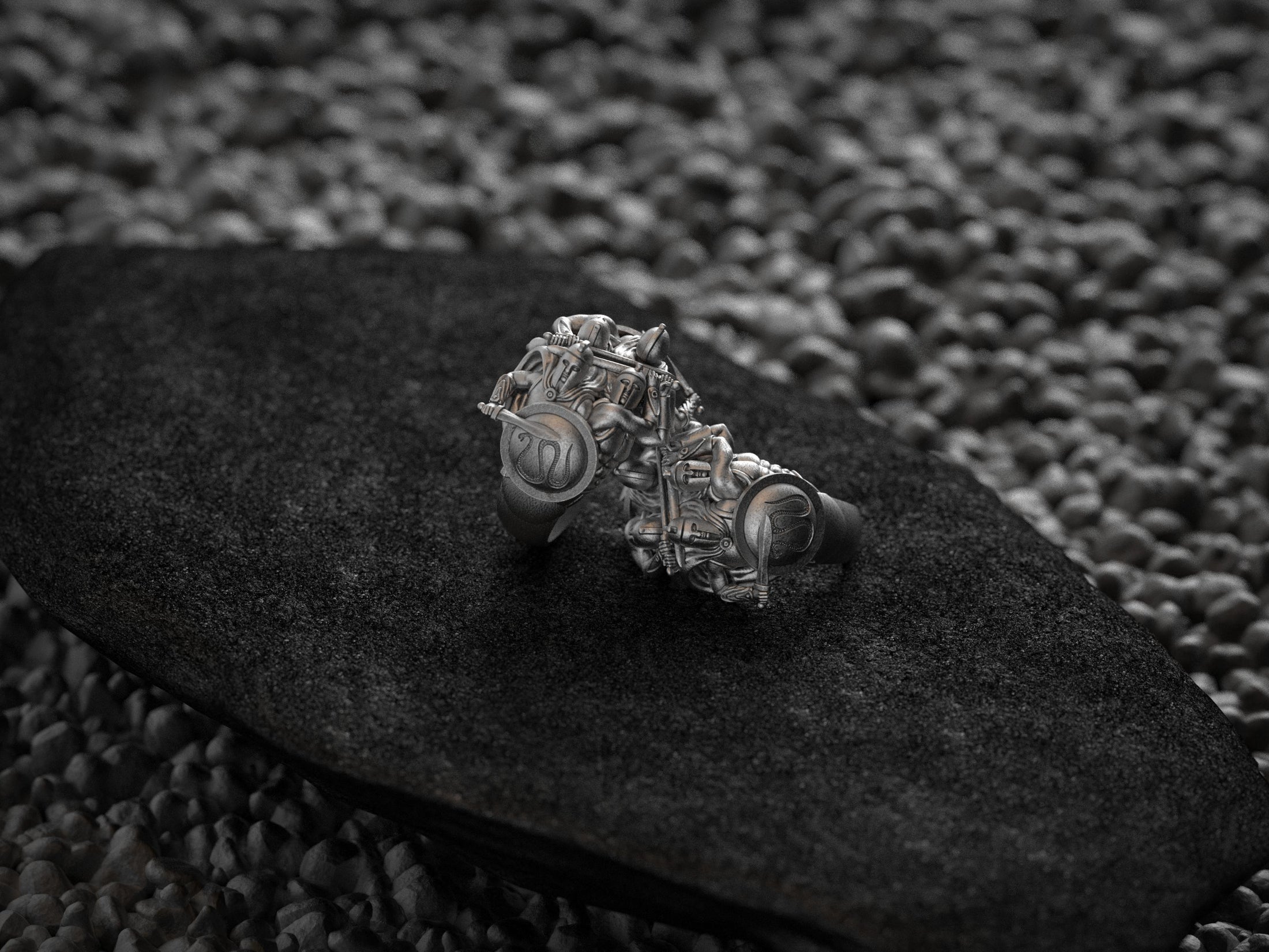 “Two matte silver Spartan Phalanx rings from rear view on a black stone slab, revealing interior band hallmarks and shield crests.”