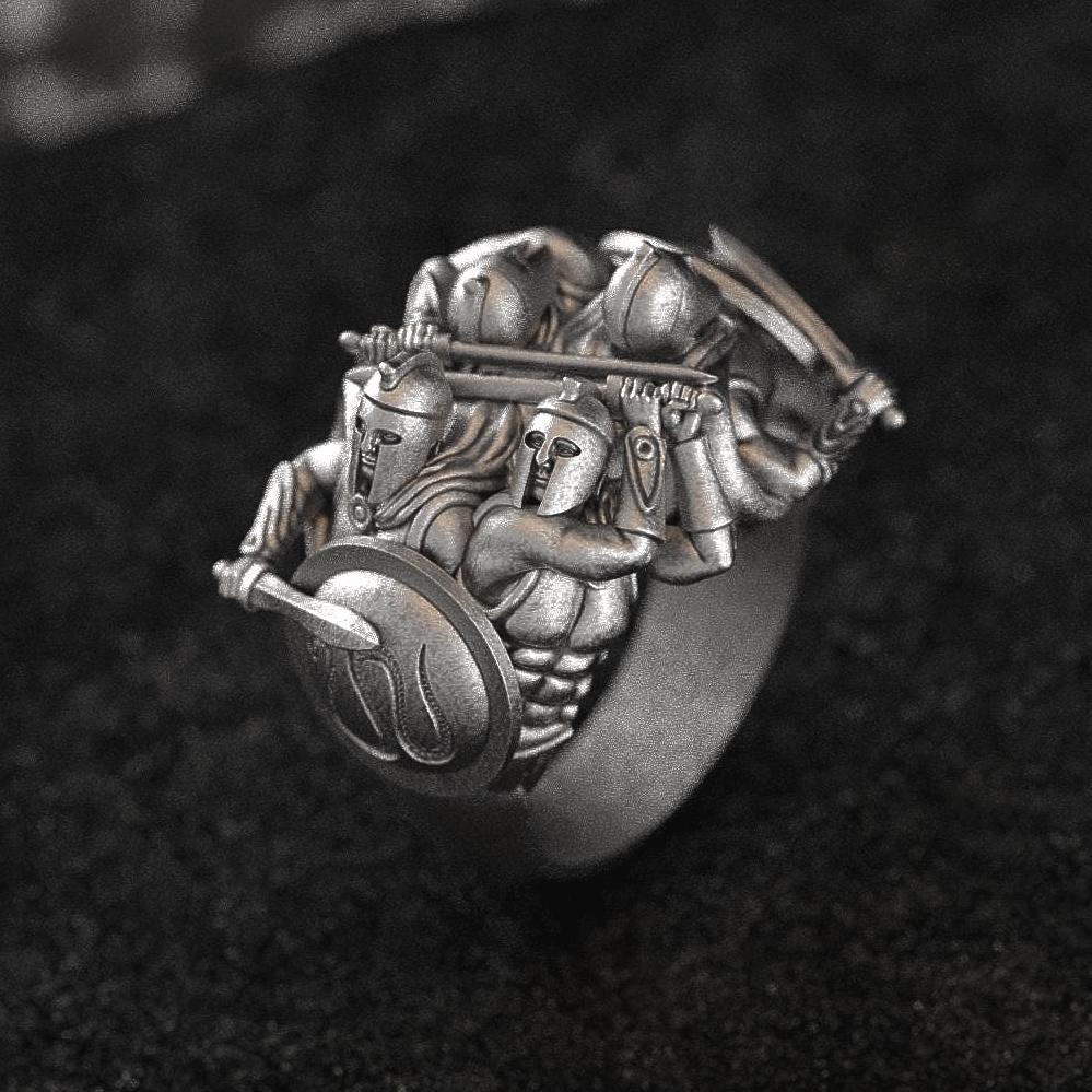 “Close-up of matte 925 sterling silver signet ring featuring three Spartan hoplites in phalanx formation on a black textured surface.”