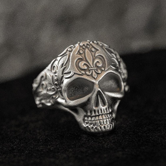 Front close-up of skull signet ring in matte silver finish.
