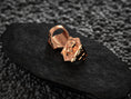 Load image into Gallery viewer, Angled shot of the rose-gold plated ring, illustrating its warm metallic sheen and embossed hexagon shape.
