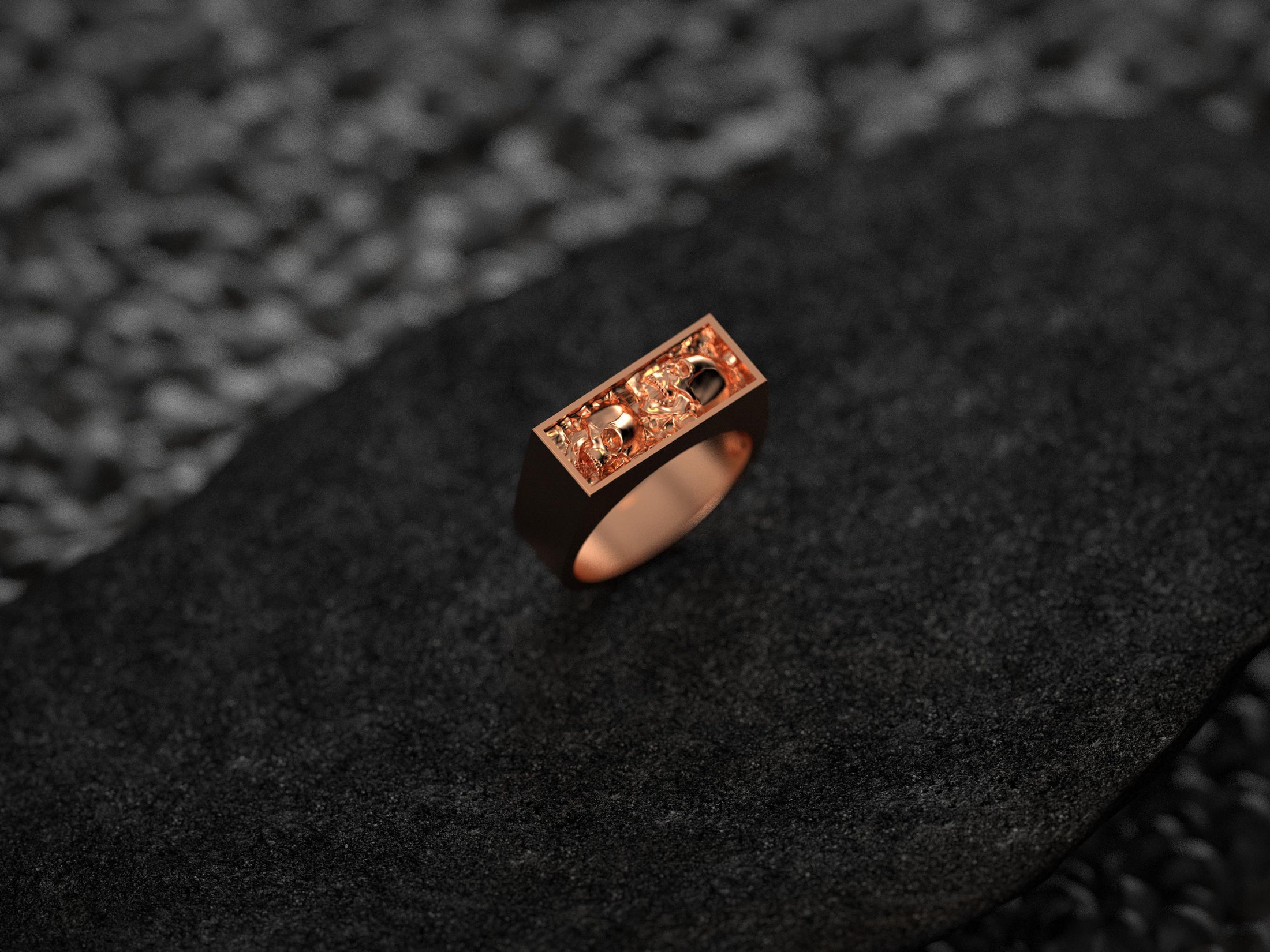 Front view of the rose-gold plated variant, showing both skull profiles framed in a slim rectangular bezel.
