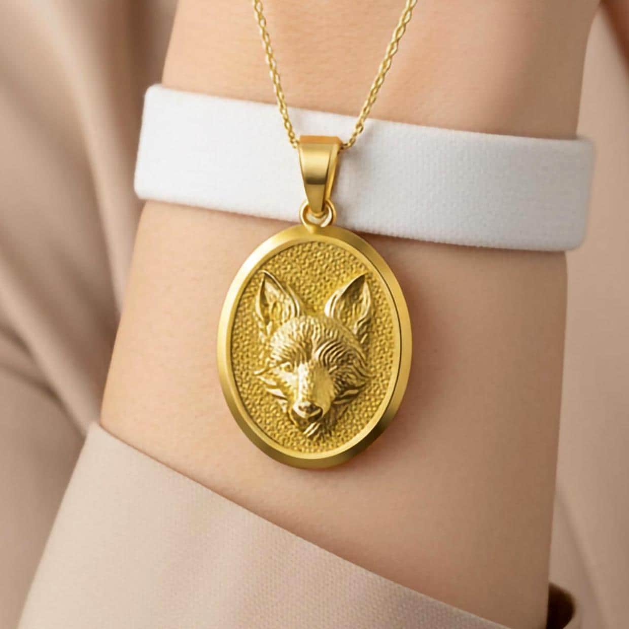 Fox head gold pendant close-up showing detailed fur texture.