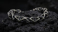Load image into Gallery viewer, Trigonal DNA Helix bracelet standing on a dark volcanic stone