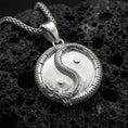 Load image into Gallery viewer, Polished silver yin yang dragon medallion necklace photographed on volcanic rock background