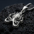 Load image into Gallery viewer, Oxidized Cthulhu octopus pendant necklace photographed on volcanic rock with deep engraved Lovecraftian detail