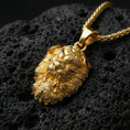 Load image into Gallery viewer, Gold plated Fu Dog guardian lion pendant showcased on volcanic rock as a symbol of protection and strength