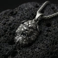 Load image into Gallery viewer, Oxidized Fu Dog pendant necklace photographed on volcanic rock with detailed Chinese guardian lion relief