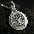 Load image into Gallery viewer, Polished silver Norse tree of life Yggdrasil pendant displayed on volcanic stone background with intricate circular relief