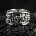 Load image into Gallery viewer, Polished silver Roman senate inspired band ring displayed on volcanic stone background highlighting sculpted human figures in procession