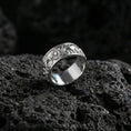 Load image into Gallery viewer, Polished silver prism facet wedding band ring displayed on volcanic stone background highlighting crisp angular pattern and reflective edges