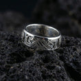 Load image into Gallery viewer, White GoldSlavic dragon band ring on volcanic stone showcasing intricate intertwined dragon design and clean unisex profile