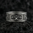 Load image into Gallery viewer, Oxidized Maltese cross Knights Hospitaller band ring photographed on volcanic rock, featuring crisp star-cross emblem and fleur de lis scrollwork detail