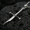 Load image into Gallery viewer, Polished silver sword necklace pendant on black volcanic stone background, clean reflections, crisp crossguard and edge
