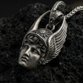 Load image into Gallery viewer, Oxidized Hermes pendant on textured volcanic rock, macro close-up, winged helmet face detail, dark premium studio lighting