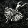 Load image into Gallery viewer, Oxidized elephant pendant on textured volcanic rock, macro close-up, detailed ears and tusks, dark premium studio lighting