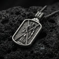 Load image into Gallery viewer, Oxidized Saint Andrew dog tag pendant on volcanic rock, macro close-up, apostle holding cross relief, premium studio lighting