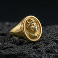 Load image into Gallery viewer, Gold plated Medusa signet ring with ancient Greek border detail photographed on volcanic rock surface