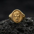 Load image into Gallery viewer, Gold plated Poseidon ring displayed on porous volcanic rock, Greek mythology king portrait, bold signet style, premium macro shot