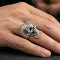 Load image into Gallery viewer, Numerology skull ring in polished silver finish on finger, raised number pattern and skull face detail, natural lifestyle wear shot