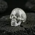 Load image into Gallery viewer, 925 sterling silver skull ring in polished silver finish on volcanic rock, raised numbers and detailed teeth carving, close-up product photo