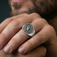 Load image into Gallery viewer, Yggdrasil ring in polished silver finish on finger, Norse Tree of Life signet with rope border, natural lifestyle wear shot