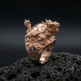 Load image into Gallery viewer, Dragon turtle ring in a rose gold plated finish on volcanic rock, ornate dragon head and turtle shell details, luxury studio close-up