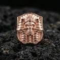 Load image into Gallery viewer, Pharaoh skull ring in a rose gold plated finish on volcanic rock, ornate Egyptian headdress with skull face detail, luxury studio close-up