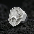 Load image into Gallery viewer, Sterling silver griffin ring in polished silver finish on volcanic rock, detailed winged gryphon engraving with textured background, close-up photo