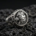 Load image into Gallery viewer, Sterling silver Fenrir wolf signet ring in an oxidized finish on volcanic rock, snarling wolf head relief with Celtic knot side engravings, macro studio product shot