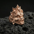 Load image into Gallery viewer, Yama mask statement ring in a rose gold plated finish on volcanic rock, detailed crown skull motifs and textured metalwork, luxury close-up image
