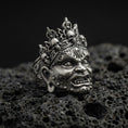 Load image into Gallery viewer, Sterling silver Yama mask ring in an oxidized finish on volcanic rock, fierce deity face with skull crown details, dramatic macro product shot