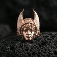 Load image into Gallery viewer, Sterling silver Hermes ring in a rose gold plated finish on volcanic rock, winged helmet feather details and sculpted face, high-end close-up