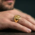 Load image into Gallery viewer, Tree of Life ring in gold finish on volcanic rock, Norse world tree motif, premium macro photography